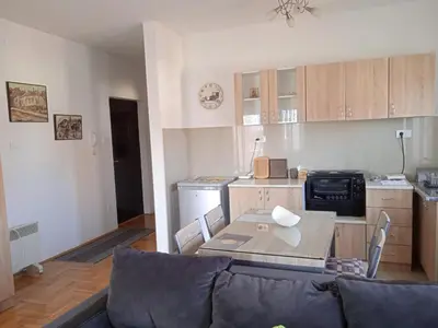 a living room with a couch and a kitchen at Apartment Srebrni oblak in Arandjelovac