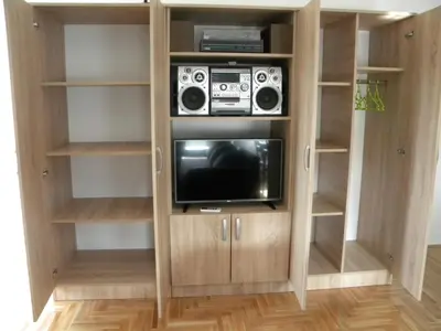 a bookcase with a television and a radio in it at Apartment Srebrni oblak in Arandjelovac