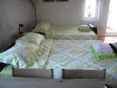 a bedroom with two beds and a table with two chairs at Apartment Srebrni oblak in Arandjelovac