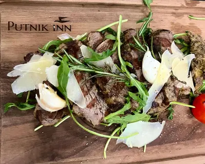 a plate of food with a salad on a cutting board at Putnik Inn Belgrade in Belgrade