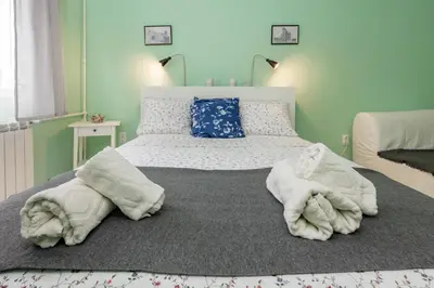 a bedroom with a bed with towels on the floor at Apartman Gloria 2 in Belgrade