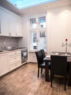 a kitchen with white cabinets and a table and chairs at Centrally Located Relaxing Place in Belgrade