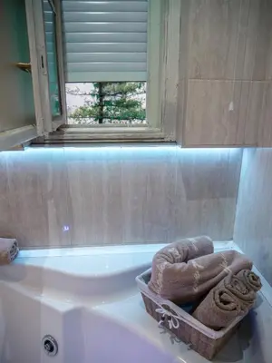a bathroom with a tub and a basket of towels at Centrally Located Relaxing Place in Belgrade