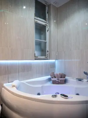 a large bath tub in a bathroom with a window at Centrally Located Relaxing Place in Belgrade