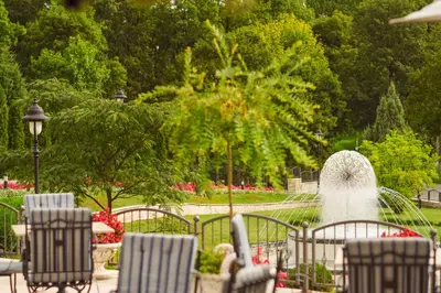 a fountain in a park with chairs and a fountain at A Hoteli - Hotel Izvor in Arandjelovac