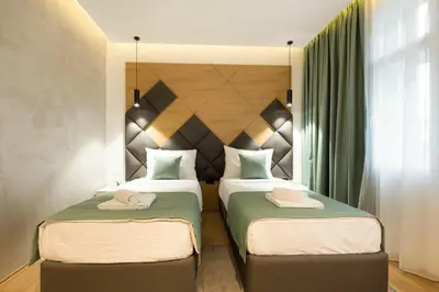 a bedroom with two beds and a headboard at Capital Hotel Garni in Belgrade
