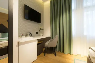 a bathroom with a sink and a desk in a room at Capital Hotel Garni in Belgrade