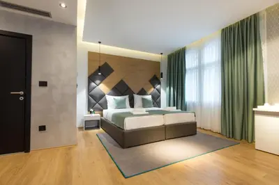 a bedroom with a bed and a large window at Capital Hotel Garni in Belgrade