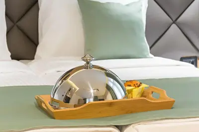 a mirror on a wooden tray on a table next to a bed at Capital Hotel Garni in Belgrade