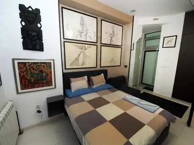 a bedroom with a bed and some pictures on the wall at KennedyLux Apartment in Belgrade