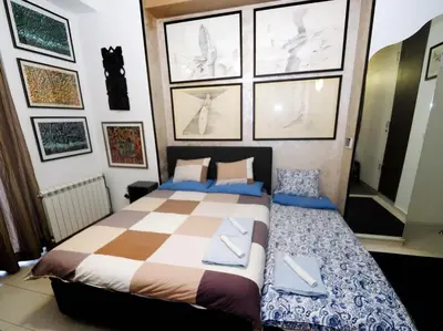 a bedroom with a bed and some pictures on the wall at KennedyLux Apartment in Belgrade