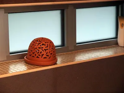 a hat sitting on a shelf in front of a window at KennedyLux Apartment in Belgrade