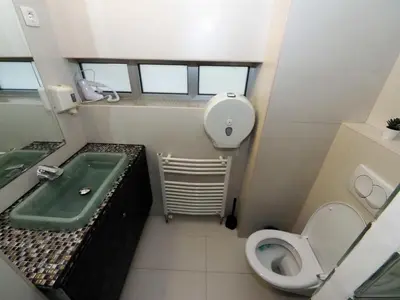 a small bathroom with a toilet and a sink at KennedyLux Apartment in Belgrade
