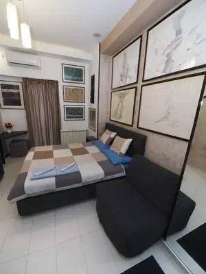 a bedroom with a large bed and a couch at KennedyLux Apartment in Belgrade