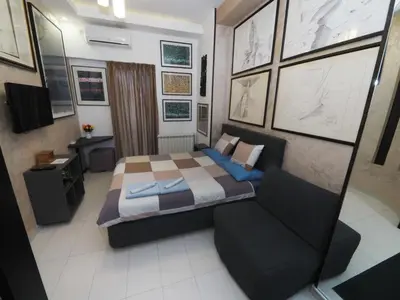 a small bedroom with a bed and a couch at KennedyLux Apartment in Belgrade