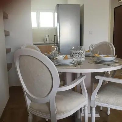 a dining room table with two chairs and a table with dishes on it at Apartment Posejdon in Belgrade