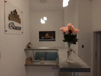 a room with a table with a vase of pink flowers at Apartment Queen in Belgrade