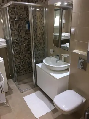 a bathroom with a sink and a shower and a toilet at Apartment Triton in Belgrade