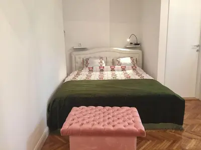 a bedroom with a bed and a pink bench at Studio 50 with Terrace in Belgrade
