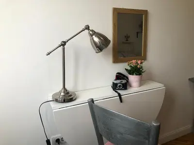 a desk with a lamp and a chair and a mirror at Studio 50 with Terrace in Belgrade