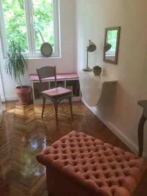 a living room with a red ottoman and a chair at Studio 50 with Terrace in Belgrade