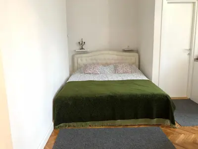 a bedroom with a bed with a green blanket at Studio 50 with Terrace in Belgrade
