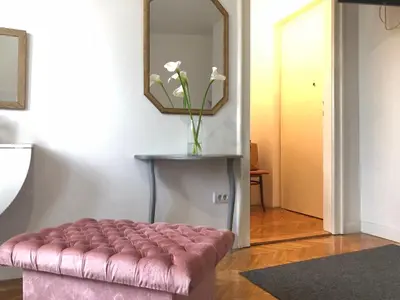 a pink ottoman in a living room with a mirror at Studio 50 with Terrace in Belgrade
