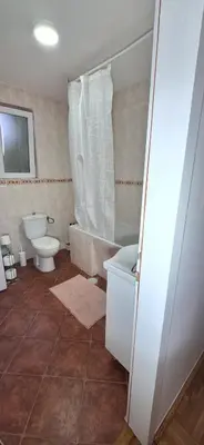 a bathroom with a toilet and a tub and a sink at ANA Apartment in Dobanovci