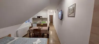 a room with a dining room and a kitchen with a table at ANA Apartment in Dobanovci