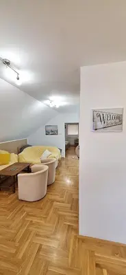 a bedroom with a bed and a wooden floor at ANA Apartment in Dobanovci