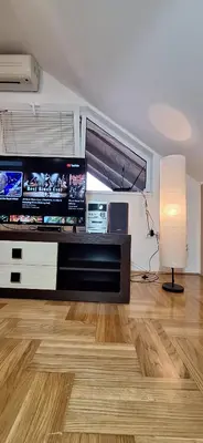 a living room with a large screen tv and a lamp at ANA Apartment in Dobanovci