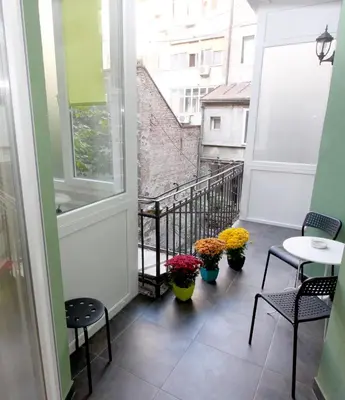 a balcony with chairs and tables and flowers on it at City Center Apartment MIKA in Belgrade