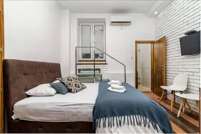 a bedroom with a bed with a blue blanket at Marcel Apartments in Belgrade