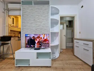 a living room with a white table with a tv on it at Marcel Apartments in Belgrade