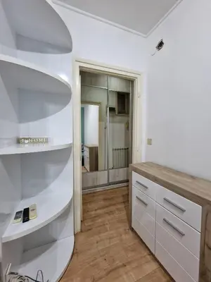 a bathroom with white shelves and a mirror at Marcel Apartments in Belgrade