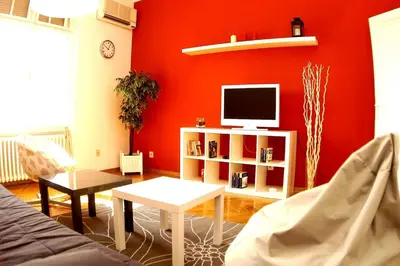a living room with a red wall and a tv at Bridge apartment in Belgrade