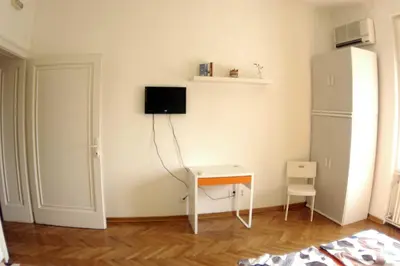 a white room with a desk and a refrigerator at Bridge apartment in Belgrade