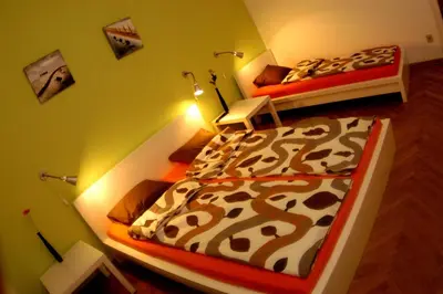 two beds in a room with green walls at Bridge apartment in Belgrade