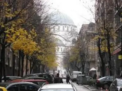 a city street with cars parked on the street at St. Sava Slavija Apartment in Belgrade