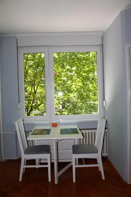 a table and two chairs in a room with a window at St. Sava Slavija Apartment in Belgrade