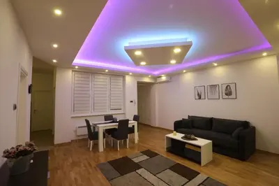 a living room with a purple light on the ceiling at De Luxe Republic Square Apartment of 100sqm in Belgrade