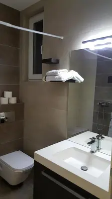 a bathroom with a sink and a toilet and a mirror at De Luxe Republic Square Apartment of 100sqm in Belgrade