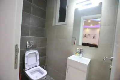 a small bathroom with a toilet and a mirror at De Luxe Republic Square Apartment of 100sqm in Belgrade
