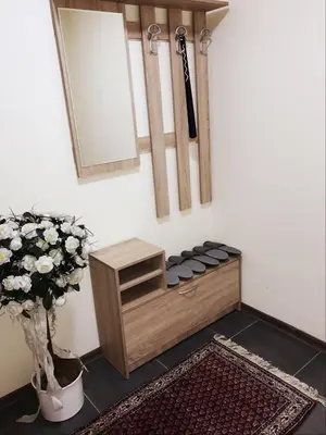 a mirror and a vase with flowers in a room at Five Apartments in Inđija