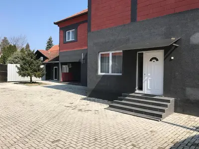 a house with a white door and a brick driveway at Five Apartments in Inđija