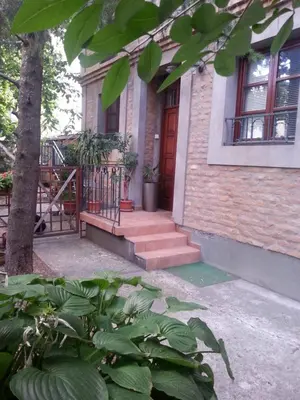 a brick house with a red door and some plants at Studio Hram in Belgrade