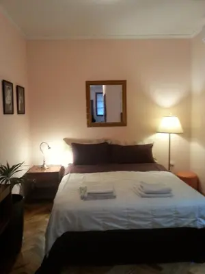 a bedroom with a large bed and a mirror at Studio Hram in Belgrade