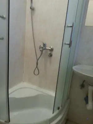 a shower with a glass door next to a sink at Studio Hram in Belgrade