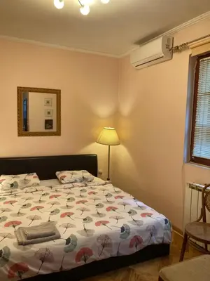 a bedroom with a bed and a lamp and a window at Studio Hram in Belgrade