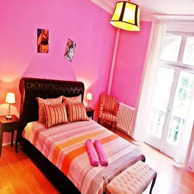 a bedroom with purple walls and a bed with pink pillows at Bel Lion Serviced Suites in Belgrade